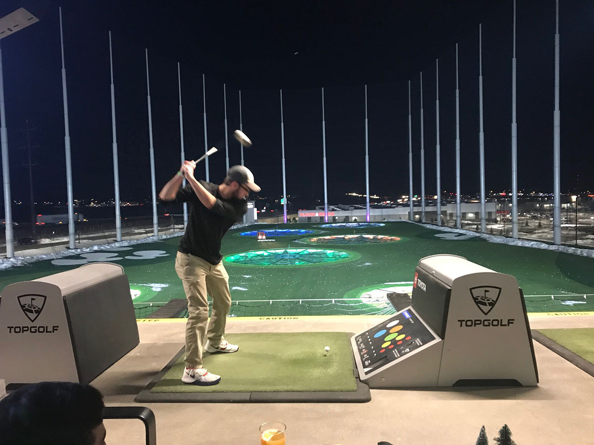 Team member playing golf at Topgolf
